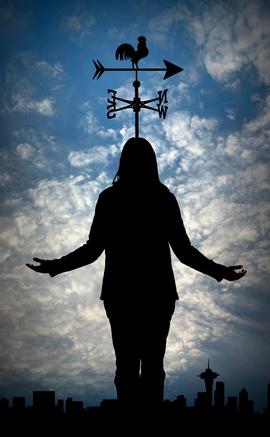 A person standing under a weather vane